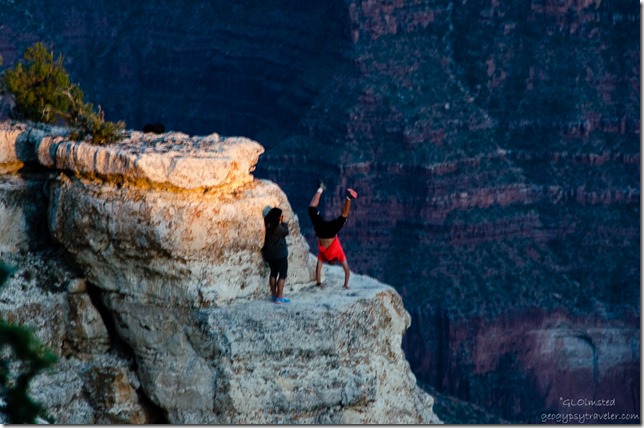 Idiot visitor doing handstand on ledge from Lodge North Rim Grand Canyon National Park Arizona