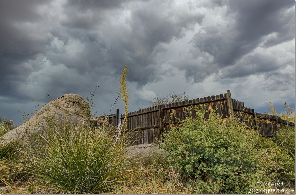 bushes fence boulder storm clouds Yarnell Arizona